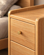 Close-up of the gold knob and the raised lip of the oak-effect top