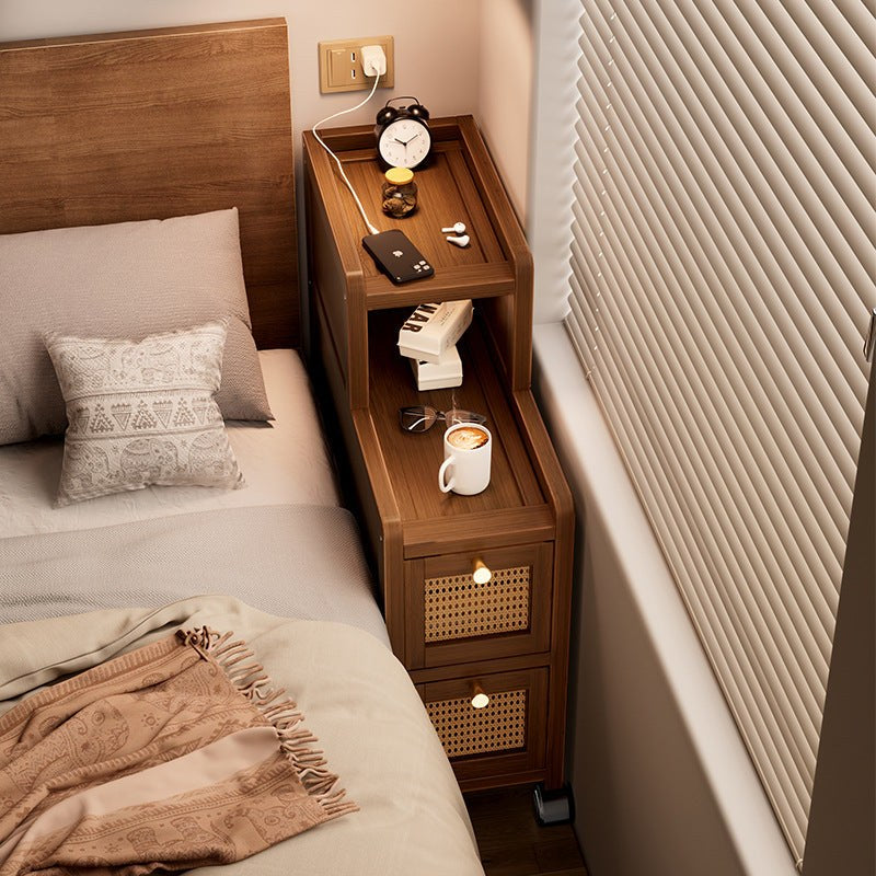 Narrow walnut bedside cabinet on wheels in a bedroom