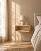 Natural wood floating bedside shelf with a ceramic lamp in warm morning light