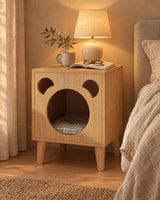 Oak bear bedside table with a pet nook, lamp switched on and an open book in the evening