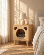 Oak bear bedside table with a cat curled up in the round opening in morning light