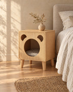 Three-quarter view of the oak bear bedside table showing the tapered wooden legs