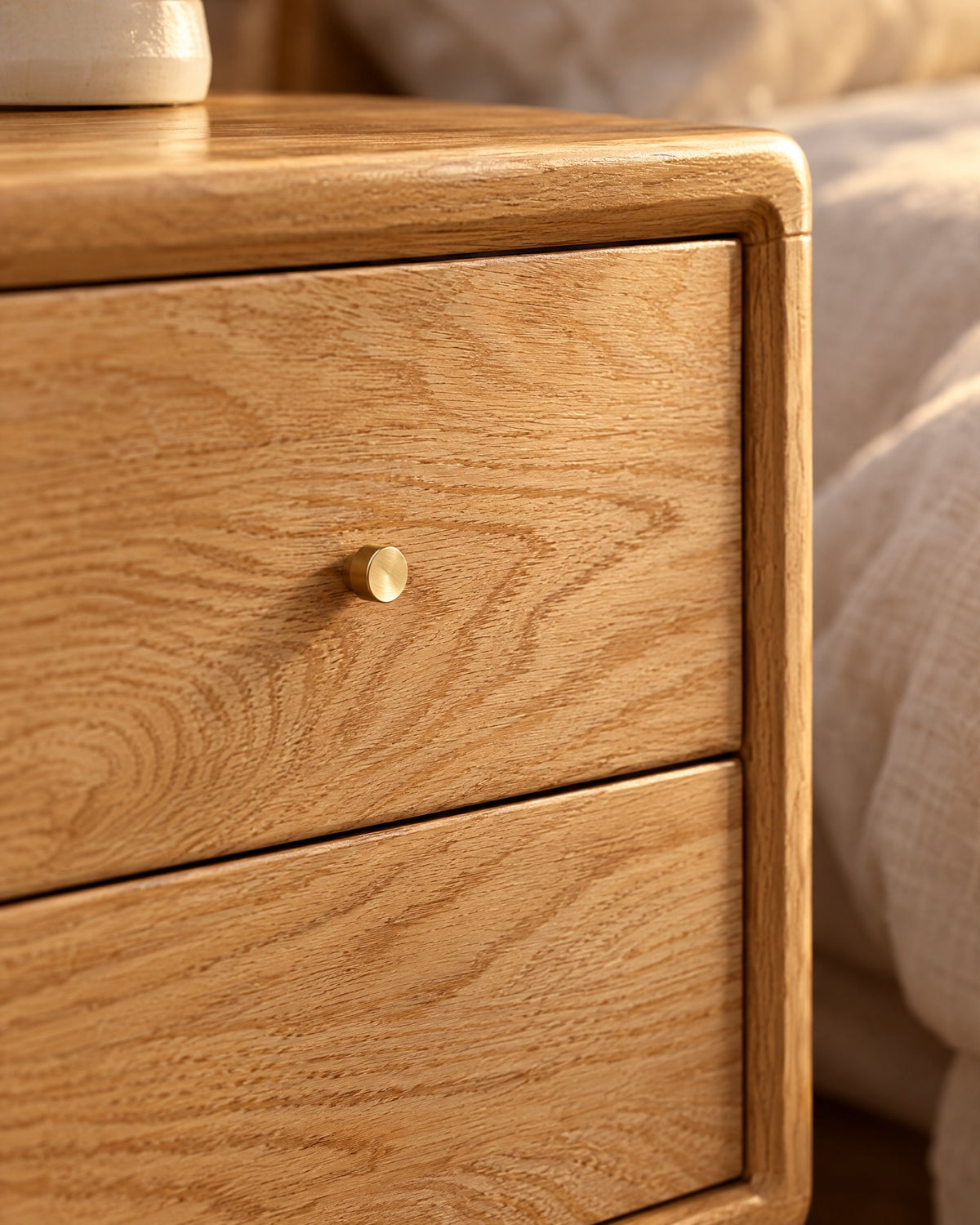 Close-up of the small brass knob and the oak grain of the drawer