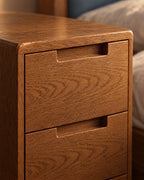 Close-up of the recessed finger pulls and oak grain of the drawers