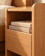 Close-up detail of the oak bedside table with an open shelf and one drawer