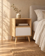 Three-quarter view of the oak-effect bedside table with open niche and white drawer beside the bed