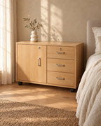 Three-quarter view of the oak bedside cabinet showing the castors