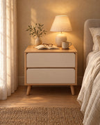Oak and white bedside table with a lamp switched on and an open book in the evening