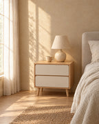 Oak bedside table with two cream-white drawers in morning light