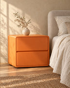 Three-quarter view of the orange rounded bedside table