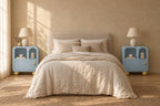 Pair of pastel blue bedside cabinets with arched niches on each side of a double bed