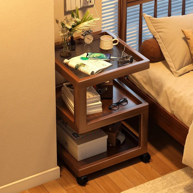 Front view of the walnut-effect rolling bedside table with three open tiers