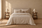Pair of round three-tier walnut-tone bedside tables with black metal legs either side of a double bed
