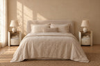 Pair of round cream bedside tables on each side of a double bed