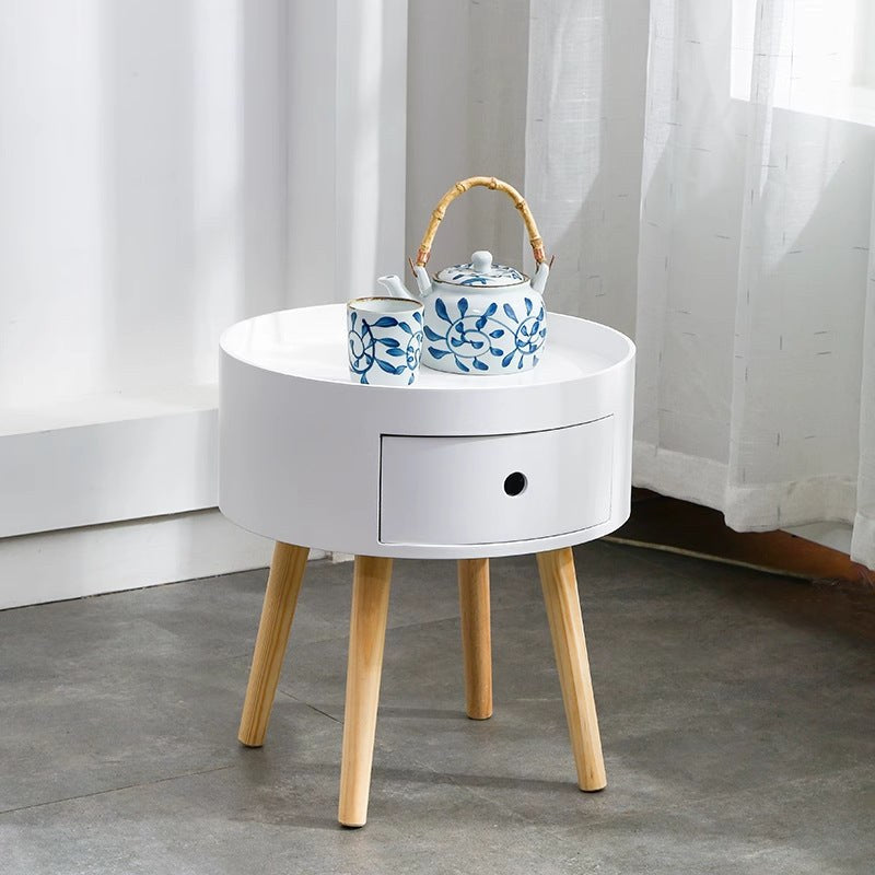 Round white bedside table with natural wood legs, supplier product photo