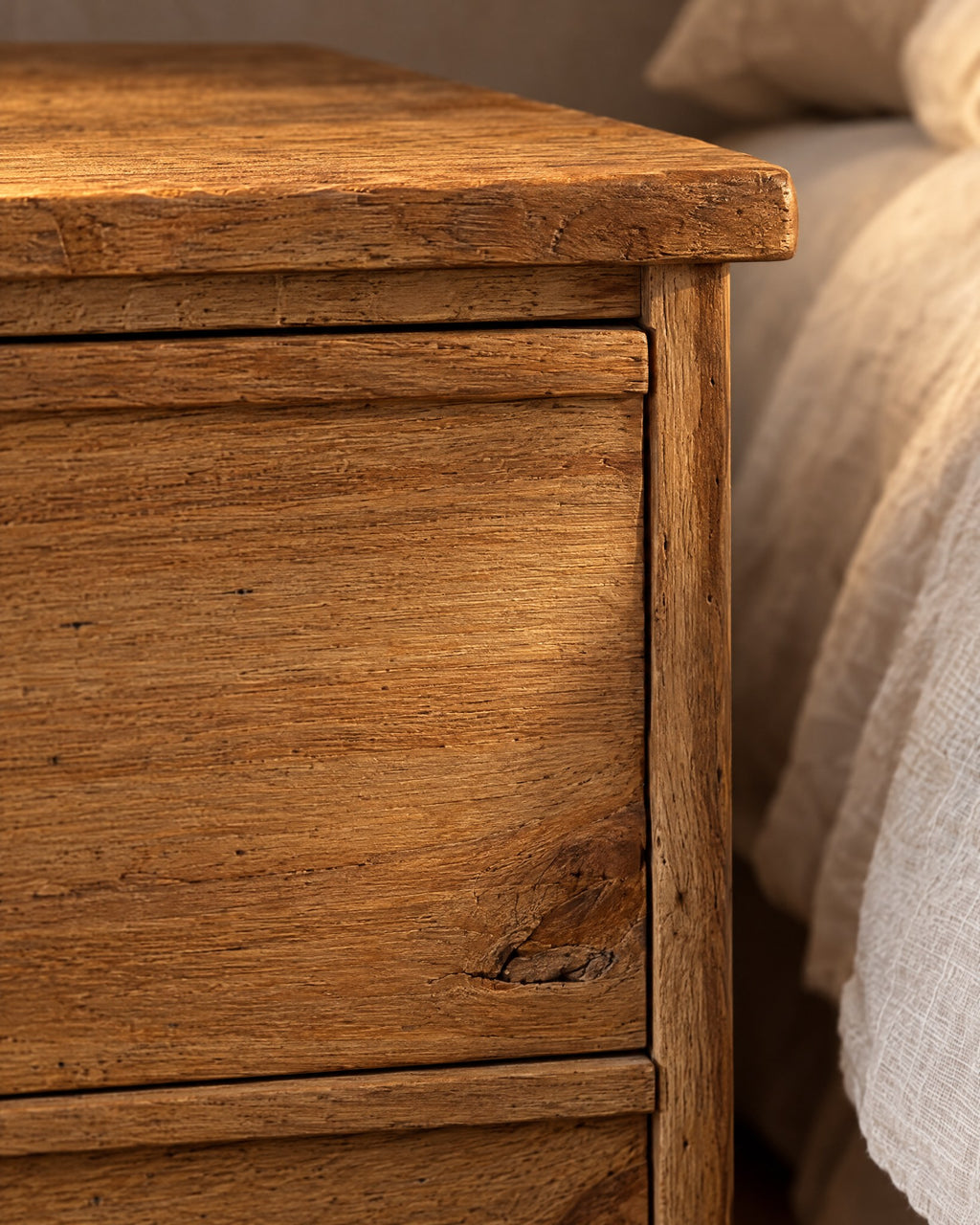 Close-up of the knotty honey-brown wood grain on a handle-free drawer front