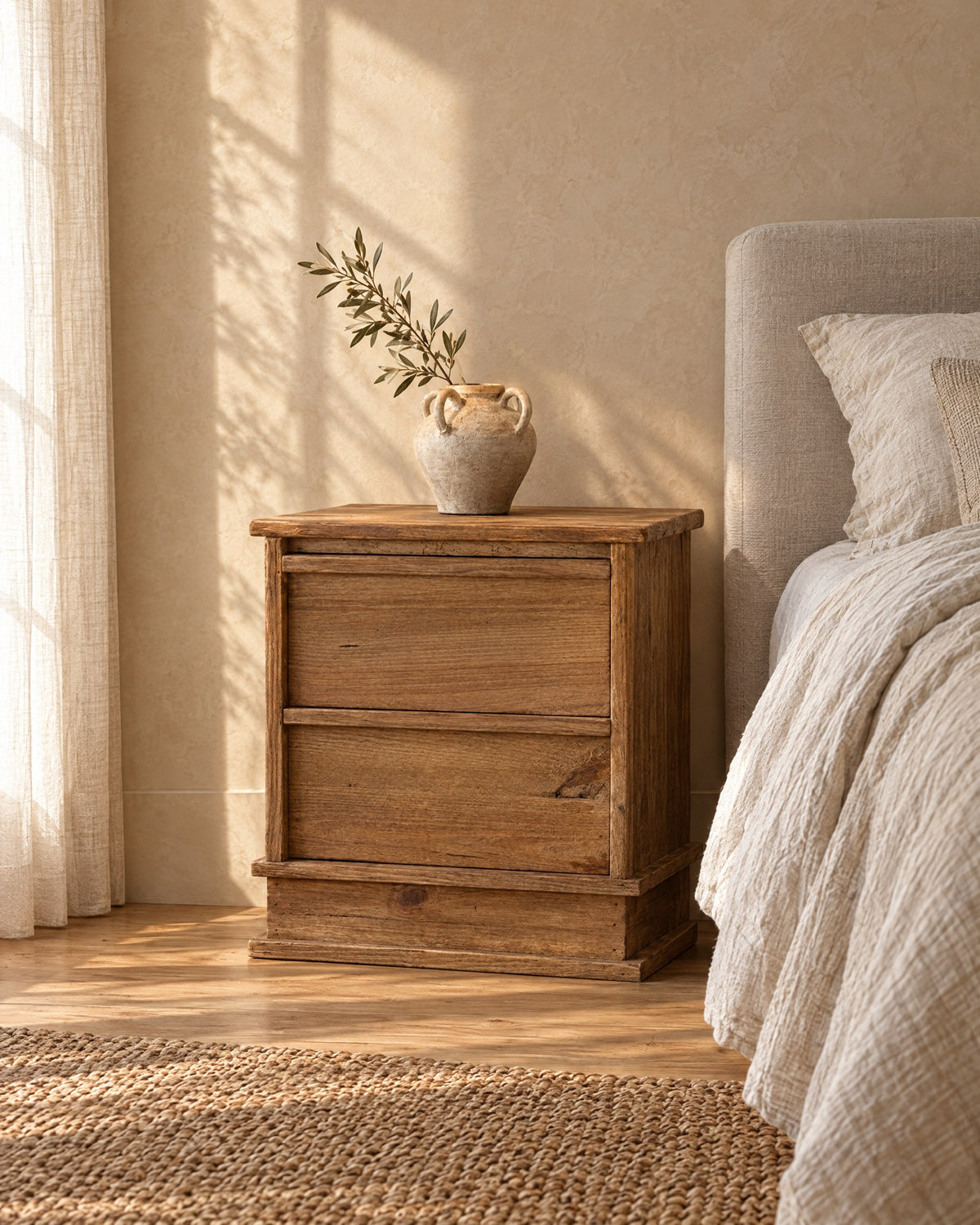 Three-quarter view of the rustic wood bedside table on a plinth base
