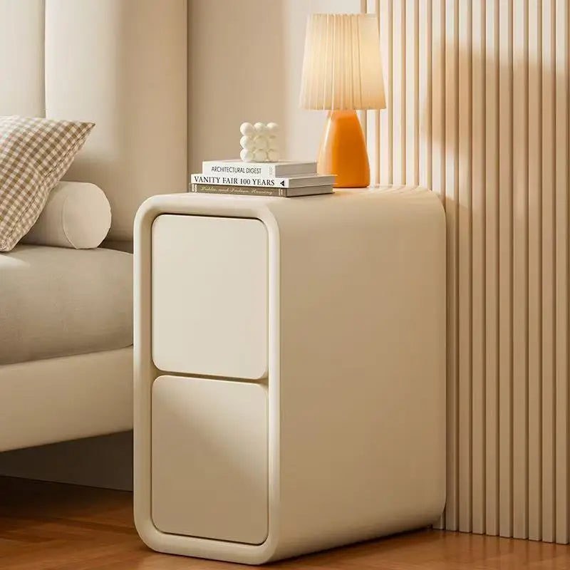 Slim cream bedside table with two handle-free drawers beside a bed