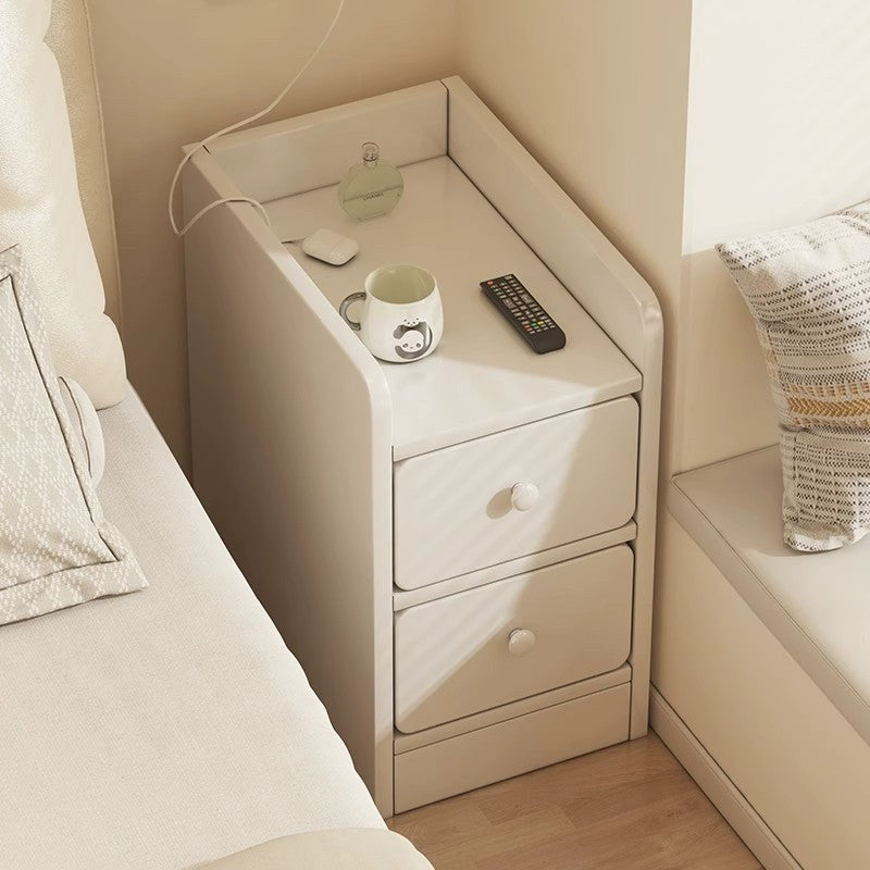 Slim cream bedside table with two drawers and a raised rim around the top