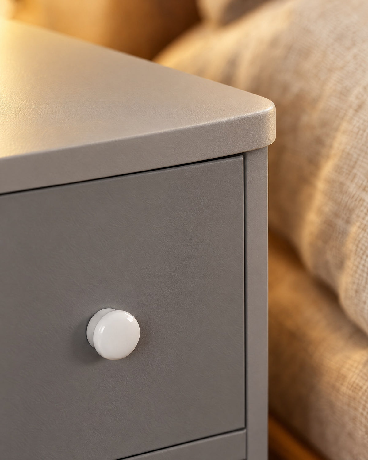 Close-up of the round white knob and the rounded grey top