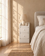 Slim white bedside table with two drawers in morning light