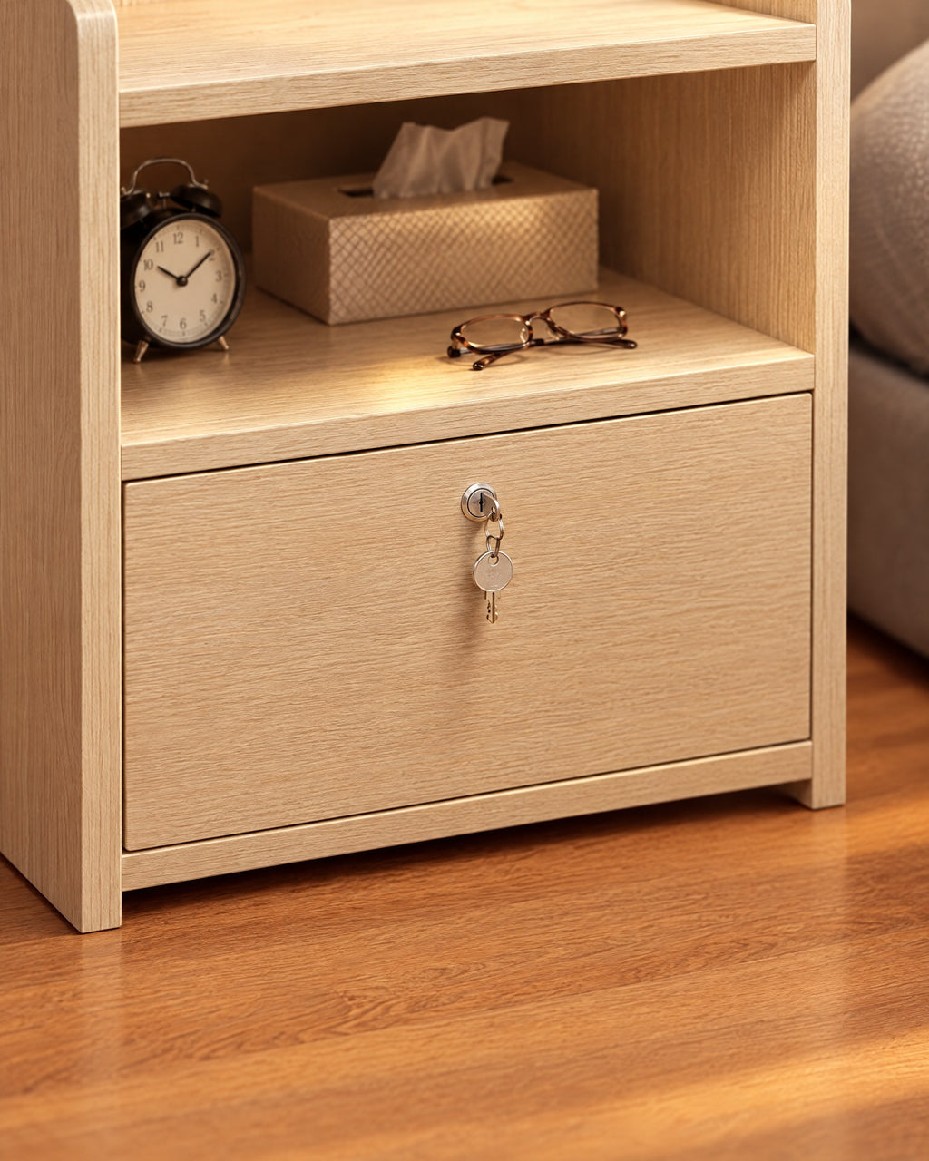 Close-up detail of the small light wood bedside table with a lockable drawer and an open shelf