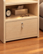 Close-up detail of the small light wood bedside table with a lockable drawer and an open shelf