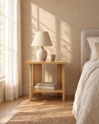 Small oak-effect bedside table with a ceramic lamp in morning light