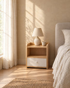 Small oak and white bedside table in warm morning light