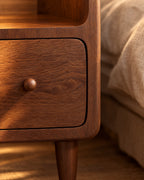 Close-up of the walnut grain and the round wooden knob of the drawer