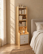 Three-quarter view of the tall oak-effect bedside table with bookcase beside the bed