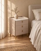 Three-quarter view of the taupe bedside table showing its slim gold legs