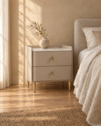 Three-quarter view of the taupe bedside table showing the slim gold legs