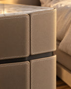 Close-up of the white contrast stitching on the taupe faux leather drawer