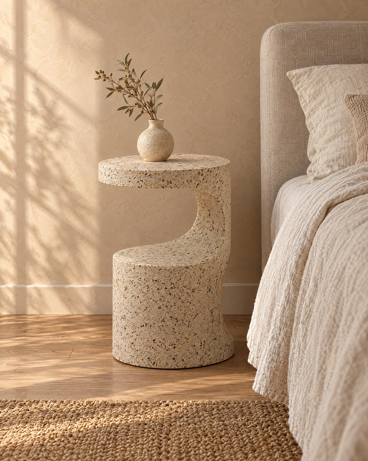 Three-quarter view of the terrazzo-look round sculpted bedside table
