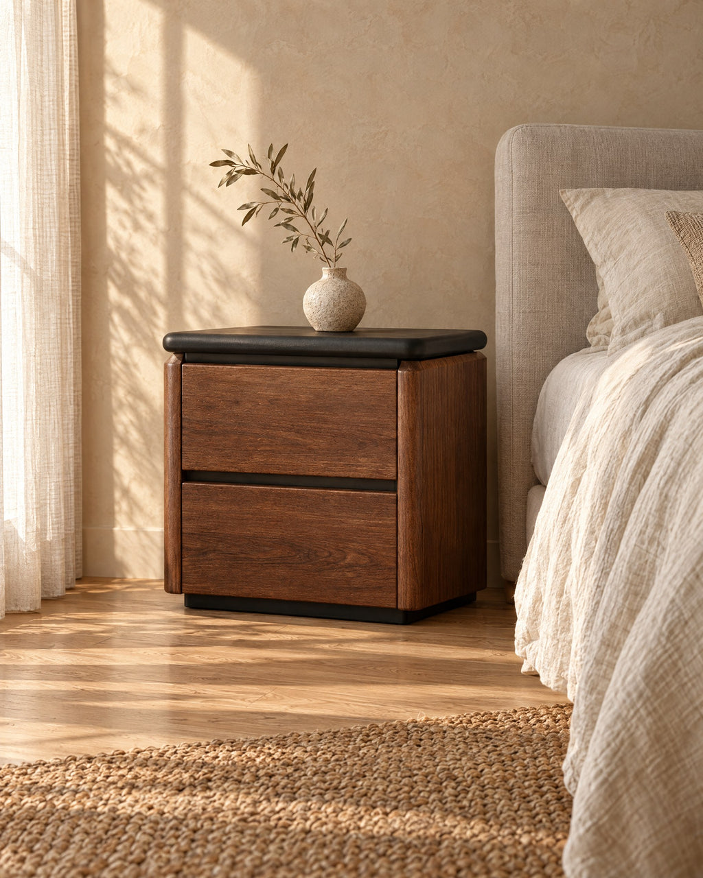 Three-quarter view of the walnut bedside table showing its rounded front edges