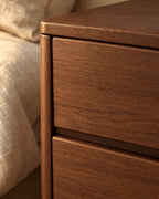 Close-up of the walnut grain and the recessed finger pull of the drawer