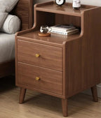 Walnut bedside table with two drawers and an open niche beside a bed