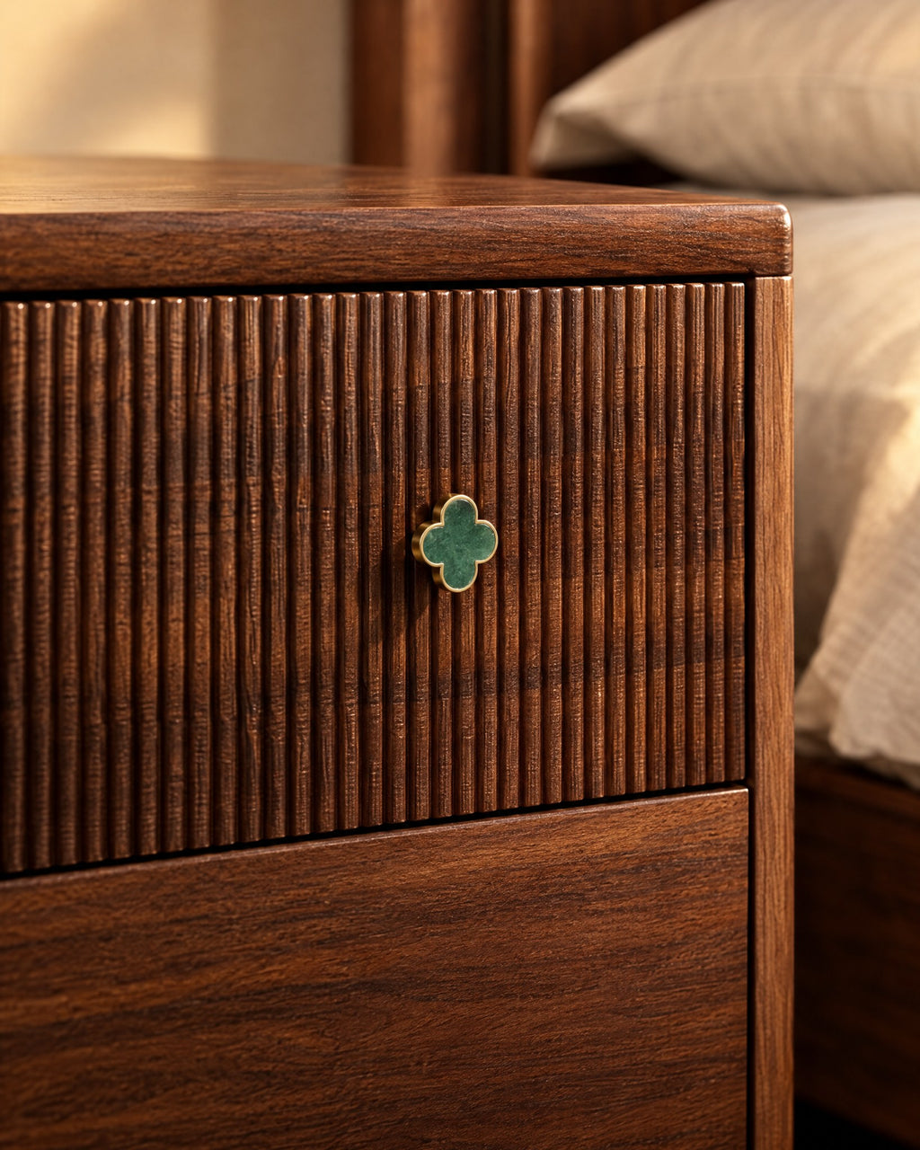 Close-up of the green four-leaf clover knob on the fluted walnut drawer front