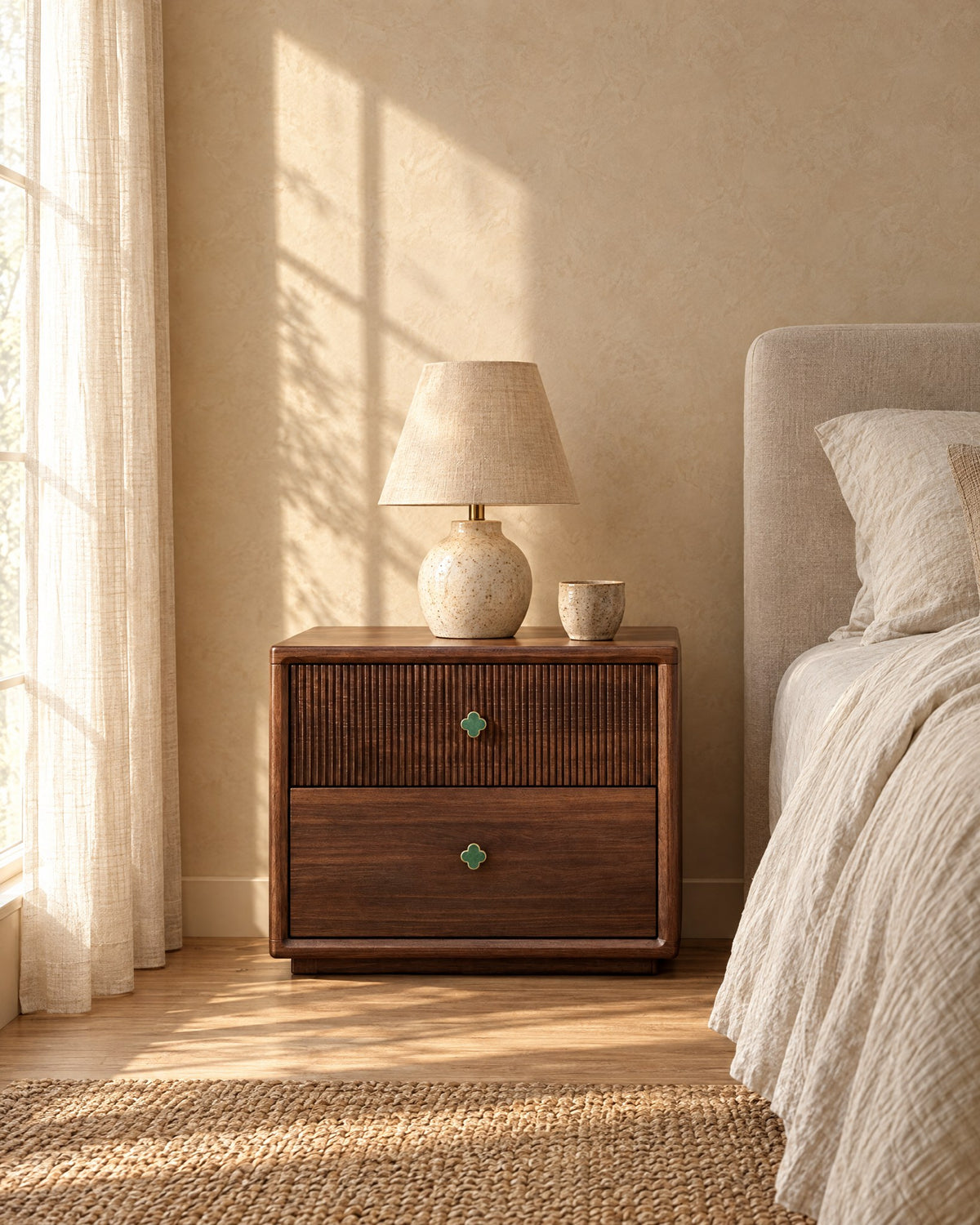 Walnut bedside table with a fluted drawer and clover knobs in warm morning light