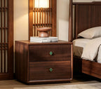 Walnut bedside table with a fluted drawer and clover knobs in a bedroom