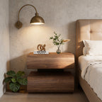 Walnut bedside table with two stacked curved drawers beside a bed