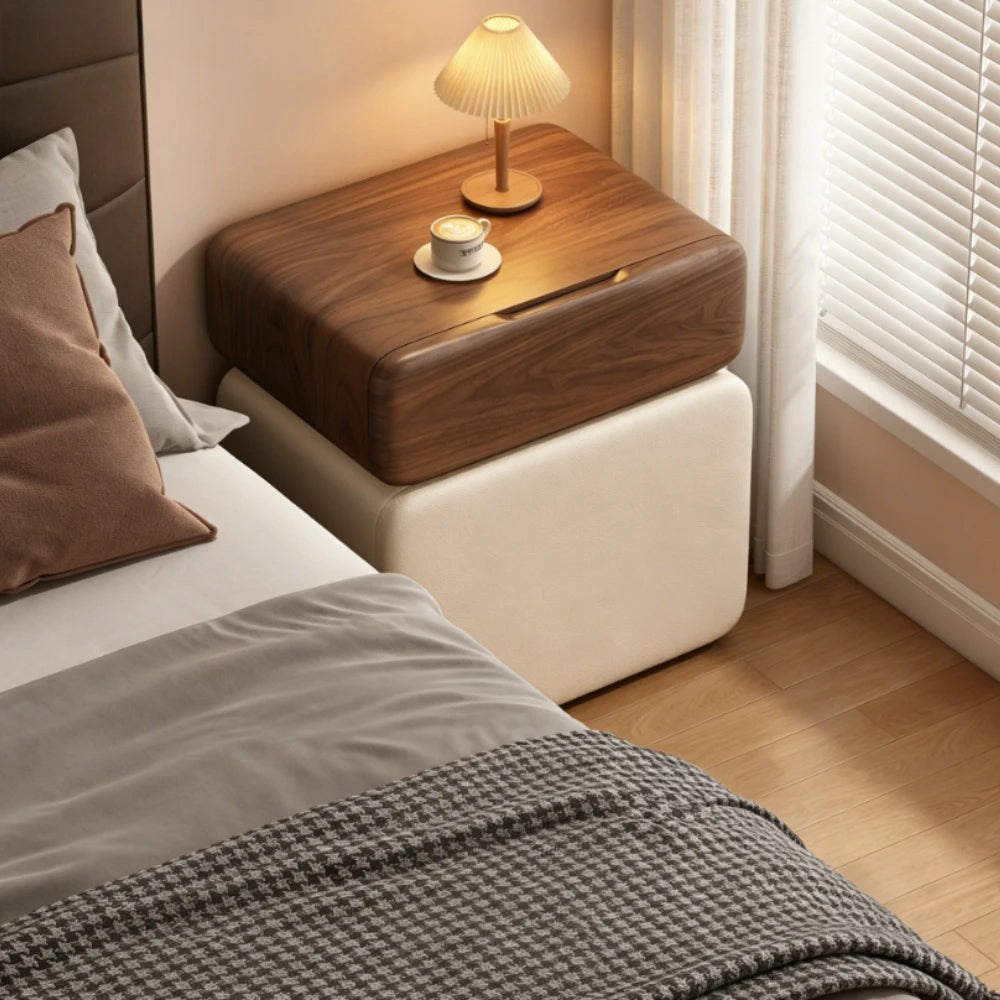 Walnut and cream bedside table with a pleated lamp beside a bed