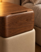 Close-up of the finger slot in the walnut drawer and the cream upholstered base