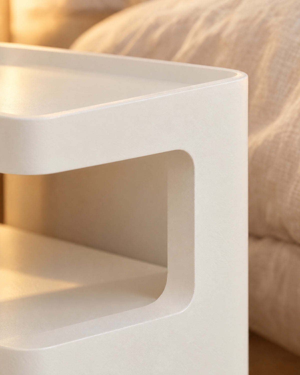 Close-up of the raised rim and rounded opening of the white bedside table