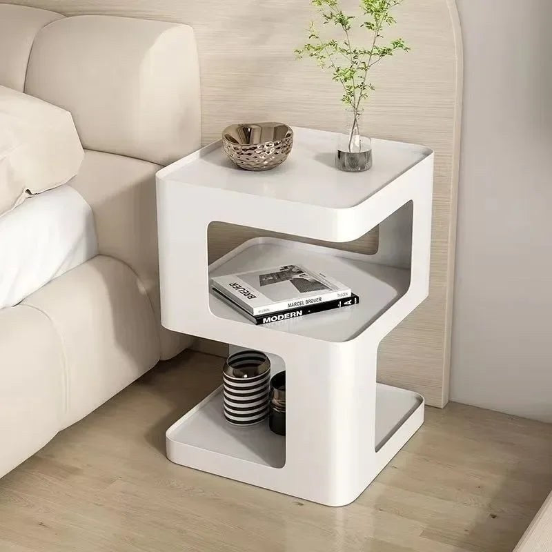 White open-tier bedside table beside a bed