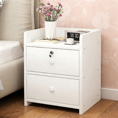 Front view of the white bedside table with two drawers and a key lock