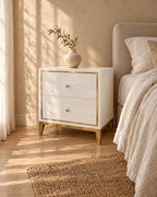 Three-quarter view of the white and gold bedside table