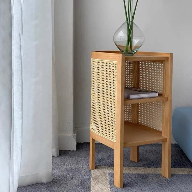 Wooden bedside table with woven cane panels and open shelves