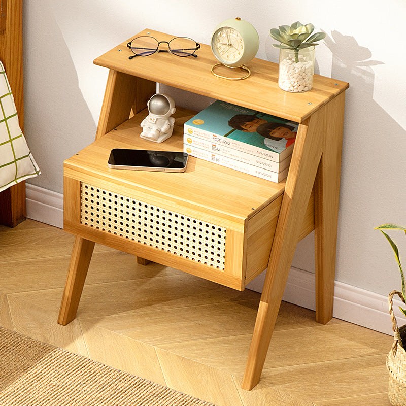 Natural wood bedside table with a rattan drawer and a raised top shelf